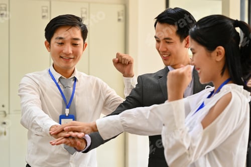 Preview: Successful business team stacking hands together at meeting.