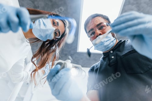 Preview: Male and female dentists working in the office together. First person view