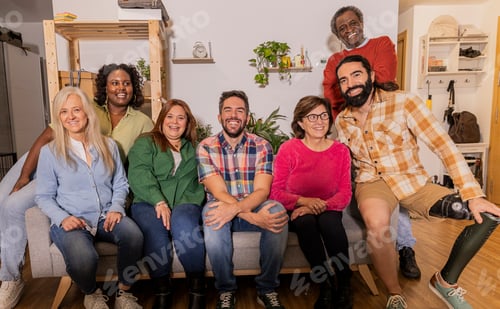 Preview: Diverse group of people smiling while sitting on sofa at home