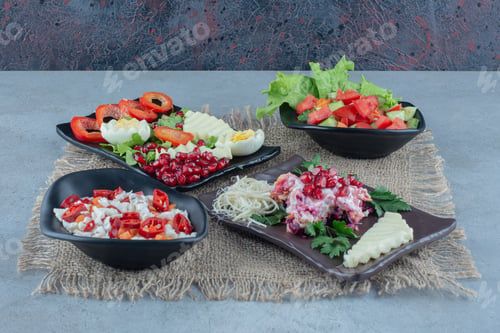 Preview: Assortment of various salads on platters on marble background