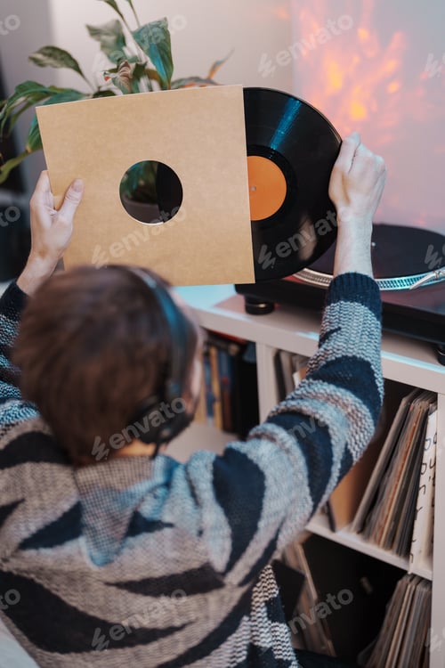 Preview: Music enthusiast holding vinyl record at home
