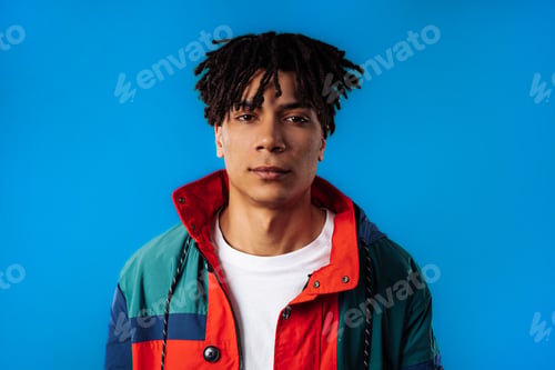 Preview: Portrait of stylish african man in colorful outfit. Handsome guy on blue studio