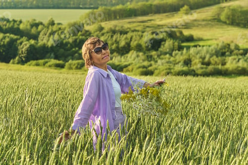 Preview: Mature Asian woman, dressed fashionably, spending a serene day in the outdoors, illustrating the