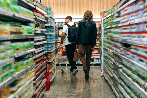 Preview: Grocery shopping trip with friends in a well-stocked supermarket aisle