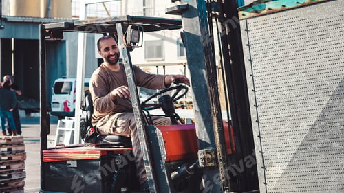 Preview: Smiling man working outside driving a forklift