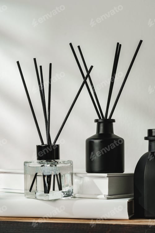 Preview: Aromatic Reed Diffuser on White Books With Shadows Playing on the Wall