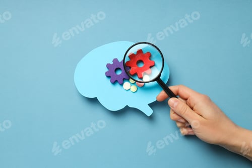 Preview: Paper brain on blue background and hand with lens
