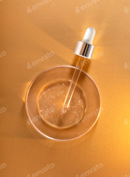 Preview: round transparent drop of clear gel serum in petri dish on gold background