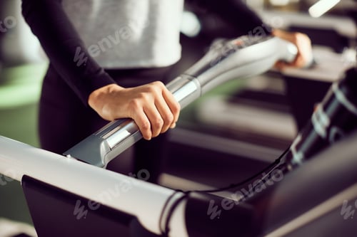 Preview: Close-up of female athlete exercising on treadmill in a gym.