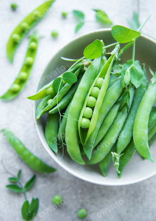 Preview: Bowl with young fresh juicy pods of green peas