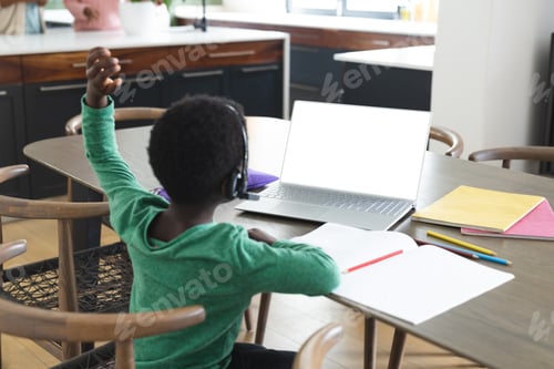 Preview: African american boy having online class using headphones and laptop with copy space, slow motion