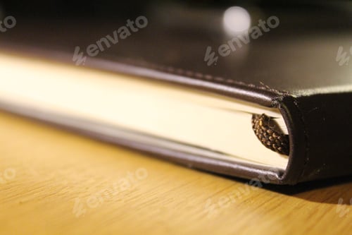 Preview: Closeup shot of a closed sketchbook with a bookmark visible
