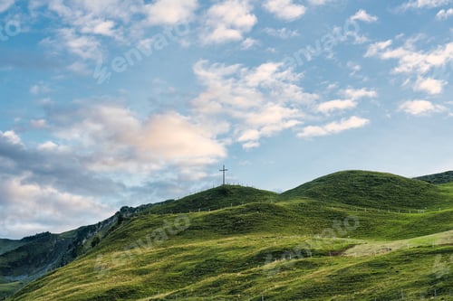Preview: Wooden cross on top of mountain and bright sky in Swiss Alps at Switzerland