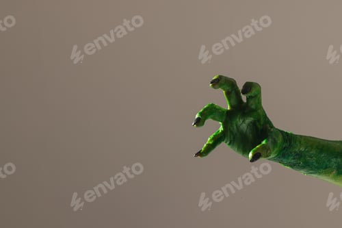 Preview: Green monster hand with black nails reaching on grey background