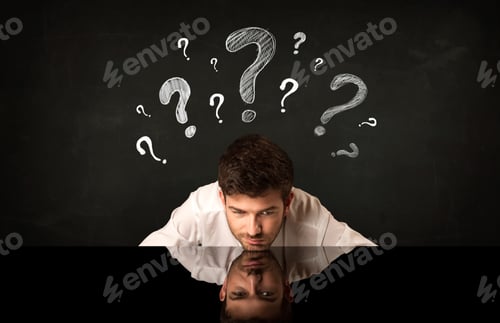 Preview: Depressed Businessman Sitting Under Question Marks
