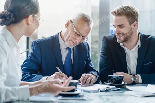 Preview: Businessman signing contract at group meeting in office