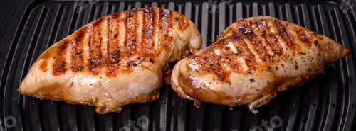 Vista previa: Delicioso filete de pollo fresco a la parrilla con especias y hierbas sobre un fondo oscuro de hormigón