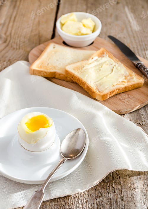 Preview: Boiled egg with crispy toasts on the wooden table