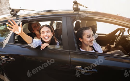 Preview: Cheerful multicultural millennials travelling together, sitting in car