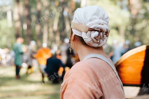 Preview: Folk women's clothing, headdress on woman's head outdoors. Back view, copy space