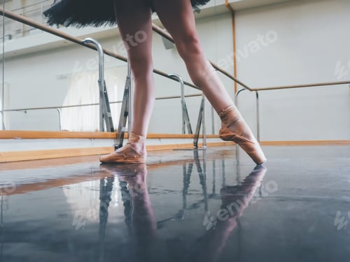 Preview: Ballerina in ballet pointe shoes stretches on barre. Woman practicing in studio