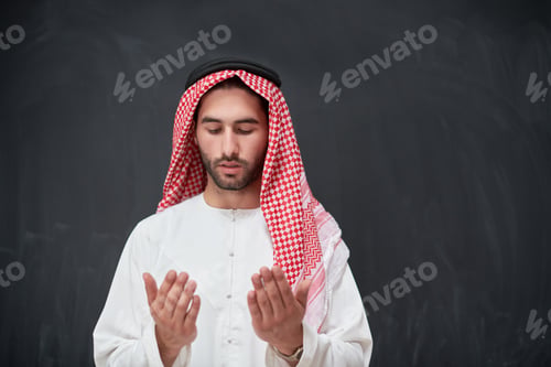 Preview: Arab man in traditional clothes praying to God or making dua
