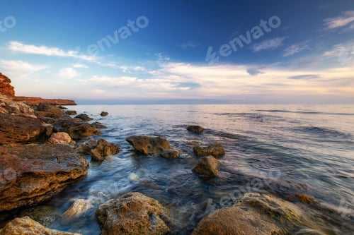 Preview: Dramatic sunset over beach with a natural pond in the foreground.