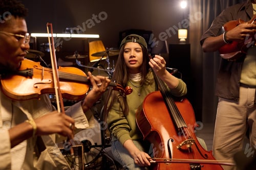 Preview: Hispanic Girl Playing Cello with Diverse Musicians during Rehearsal