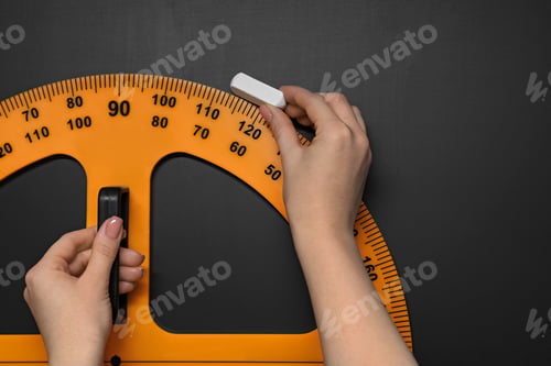 Preview: Woman drawing with chalk and protractor on blackboard, closeup