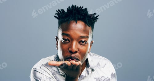 Preview: Black man, portrait and blowing with kiss for affection, love or romance on a blue studio backgroun