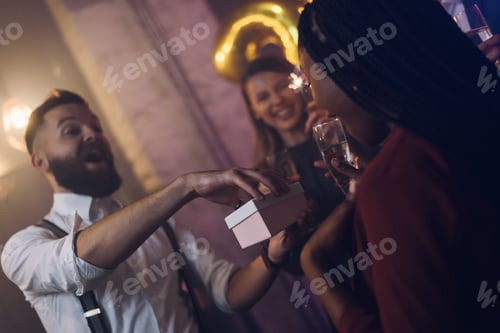 Visualização: Casal feliz comemora a véspera de Ano Novo com seus amigos e trocando presentes