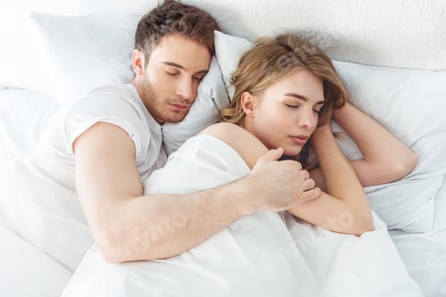 Preview: young beautiful couple sleeping in bed in bedroom