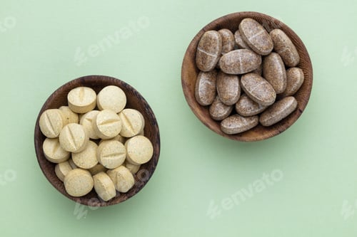 Preview: Alternative medicine tablets on a wooden spoon.