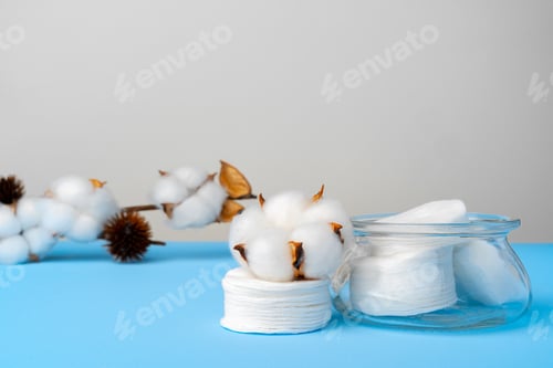 Preview: Cotton discs stack on blue paper background