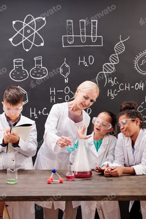 Preview: Group of clever students of secondary school watching chemical experiment