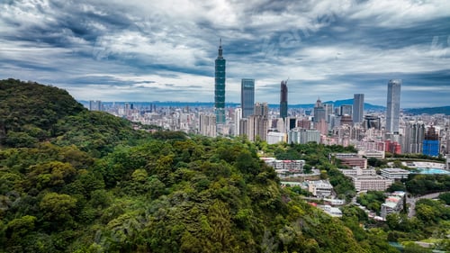 Preview: Taipeis skyline blends lush greenery with modern architecture under cloudy skies
