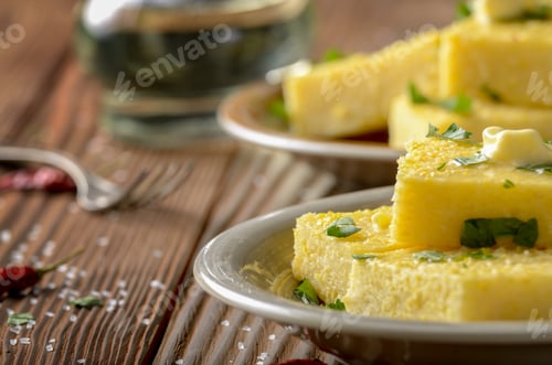 Preview: Polenta with butter and greens on clay dish on wooden rustic tab