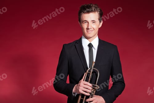 Preview: Retro Fifties Trumpet Player Wearing Black Suit. Holding His Trumpet. Red Background.