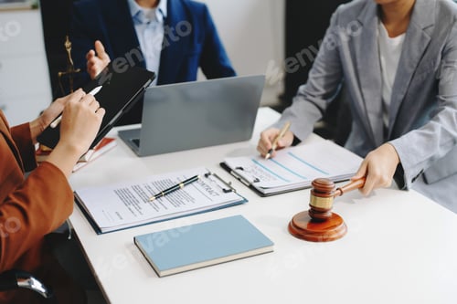 Preview: business people and lawyers discussing contract papers sitting at the table.