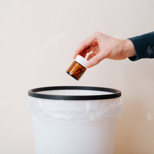 Preview: Close-up of person throwing out medicines, jar of pills in trash can