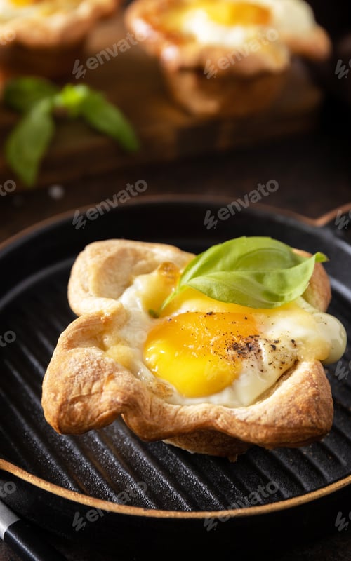 Preview: Breakfast idea. Scrambled eggs in puff pastry with cheese and bacon on a stone plate.
