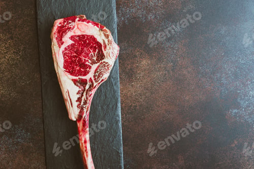 Preview: Top view of raw dry-aged marble beef steak Tomahawk. Flat lay, copy space, cooking concept.