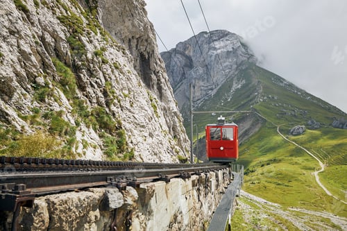 Preview: Cogwheel train passing mountain landscape of Swiss Alps