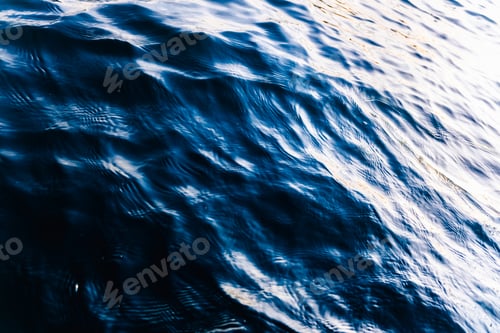 Preview: Waves on the surface of the sea water at dusk with compact, solid and deeply calm texture.