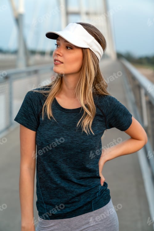 Preview: YYoung smiling satisfied fit woman resting after an active fitness training outdoors in city