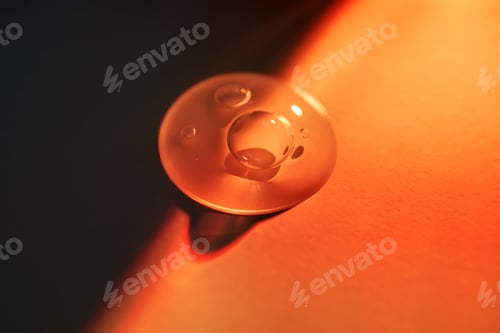 Preview: A drop of sunscreen body gel in the orange sunset light.
