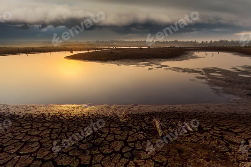 Preview: Cracked Earth Reflecting Dramatic Sky At Sunset