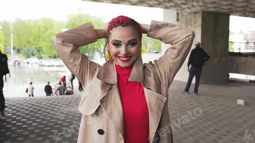 Preview: Fashionable girl in a jacket straightens her colored african braids