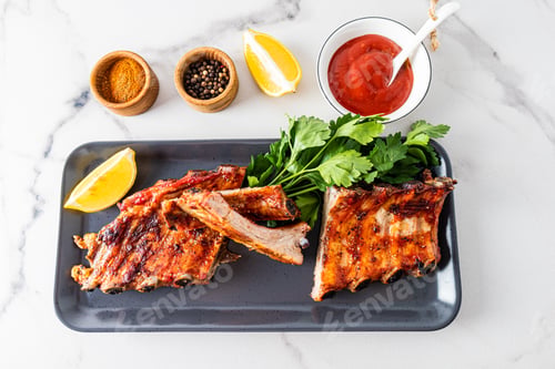 Preview: grilled pork ribs on a ceramic rectangular plate with tomato slices. sauce to improve the taste.