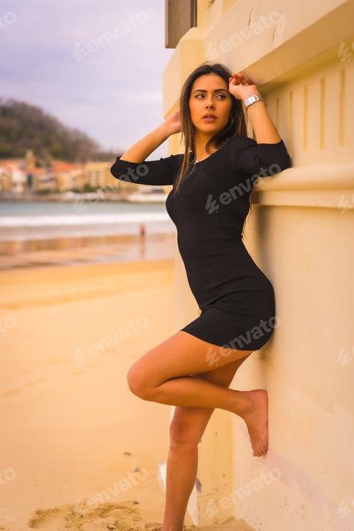 Preview: Portrait of a young brunette Caucasian from the back in a short black dress